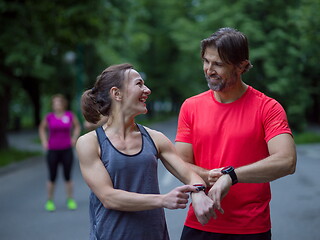 Image showing sporty couple using smart watches