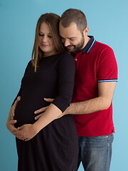Image showing pregnant couple  isolated over blue background