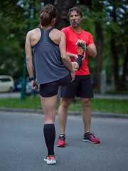 Image showing runners team warming up and stretching before morning training