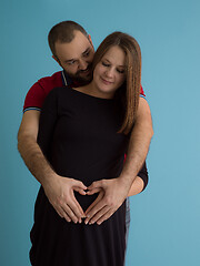 Image showing pregnant couple  isolated over blue background