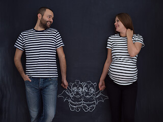 Image showing pregnant couple drawing their imaginations on chalk board