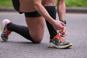 Image showing sporty woman tying running shoes laces