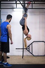 Image showing woman working out with personal trainer on gymnastic rings