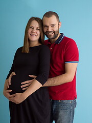 Image showing pregnant couple  isolated over blue background