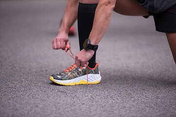 Image showing sporty woman tying running shoes laces