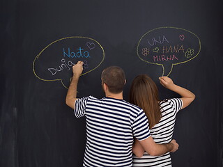 Image showing pregnant couple writing on a black chalkboard