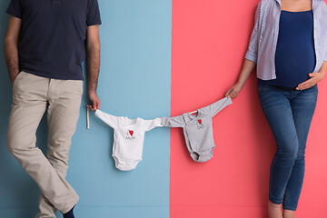 Image showing young couple holding baby bodysuits