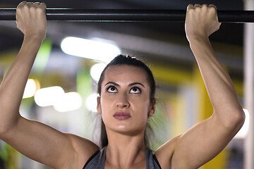 Image showing woman doing pull ups on the horizontal bar