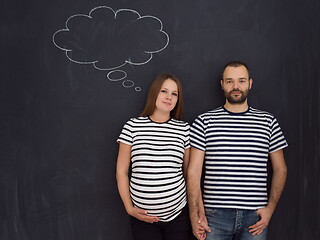 Image showing pregnant couple posing against black chalk drawing board