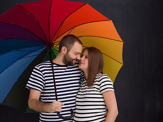 Image showing pregnant couple posing with colorful umbrella