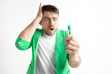 Image showing Upset man looking in pregnancy test. Frustrated model