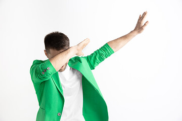 Image showing Young man makes the dab movement with his arms on a gray background.