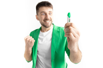 Image showing Happy man looking at pregnancy test at studio