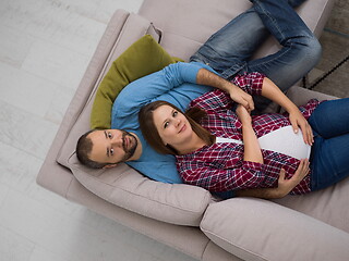 Image showing pregnant couple relaxing on sofa