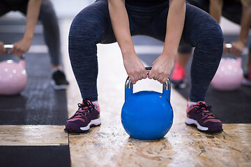 Image showing athletes doing exercises with kettlebells