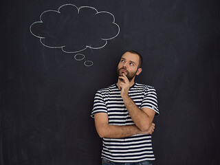 Image showing young future father thinking in front of black chalkboard