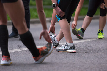 Image showing runners team warming up and stretching before morning training