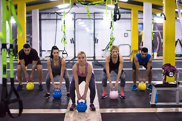 Image showing athletes doing exercises with kettlebells