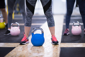 Image showing athletes doing exercises with kettlebells