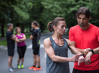 Image showing sporty couple using smart watches