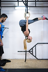 Image showing woman working out with personal trainer on gymnastic rings