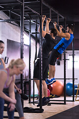 Image showing young athletes doing pull ups on the horizontal bar