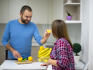 Image showing couple cooking food fruit lemon juice at kitchen