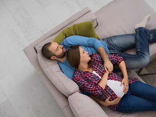 Image showing pregnant couple relaxing on sofa