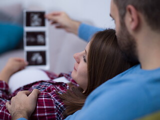 Image showing pregnant couple looking baby\'s ultrasound