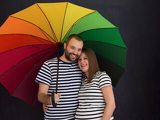 Image showing pregnant couple posing with colorful umbrella