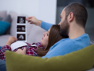 Image showing pregnant couple looking baby\'s ultrasound