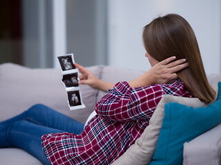 Image showing pregnant woman looking baby\'s ultrasound