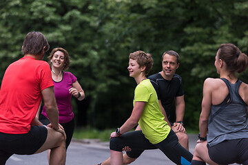 Image showing runners team warming up and stretching before morning training