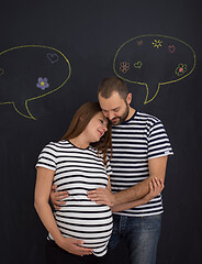 Image showing pregnant couple posing against black chalk drawing board