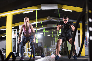 Image showing sports couple doing battle ropes cross fitness exercise