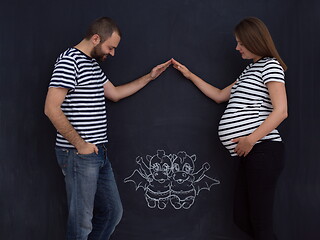 Image showing pregnant couple drawing their imaginations on chalk board