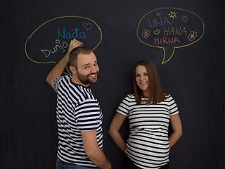 Image showing pregnant couple writing on a black chalkboard