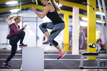 Image showing athletes working out  jumping on fit box