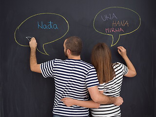 Image showing pregnant couple writing on a black chalkboard