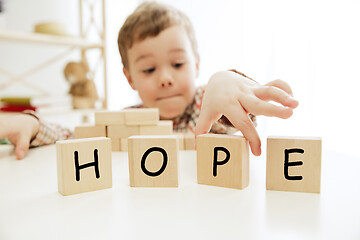 Image showing Wooden cubes with word HOPE in hands of little boy