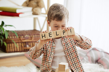 Image showing Wooden cubes with word HELP in hands of little boy