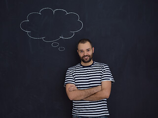 Image showing young future father thinking in front of black chalkboard