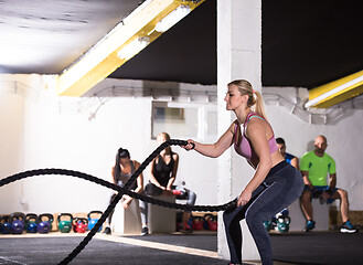 Image showing athlete woman doing battle ropes cross fitness exercise