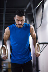 Image showing man working out pull ups with gymnastic rings