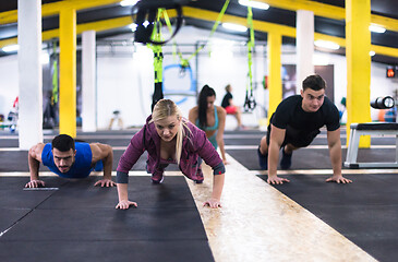 Image showing young healthy people doing pushups