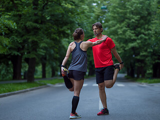 Image showing runners team warming up and stretching before morning training