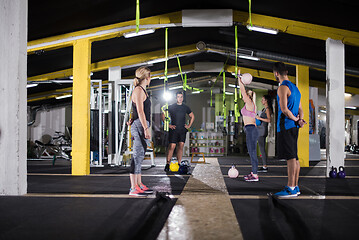 Image showing athletes doing exercises with kettlebells