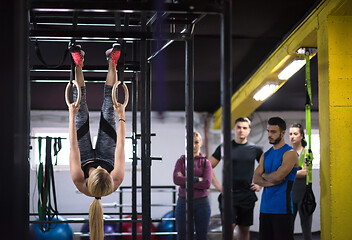 Image showing woman working out with personal trainer on gymnastic rings