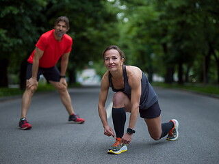 Image showing sporty woman tying running shoes laces