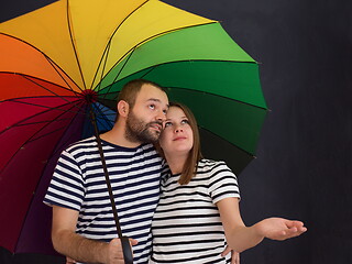 Image showing pregnant couple posing with colorful umbrella